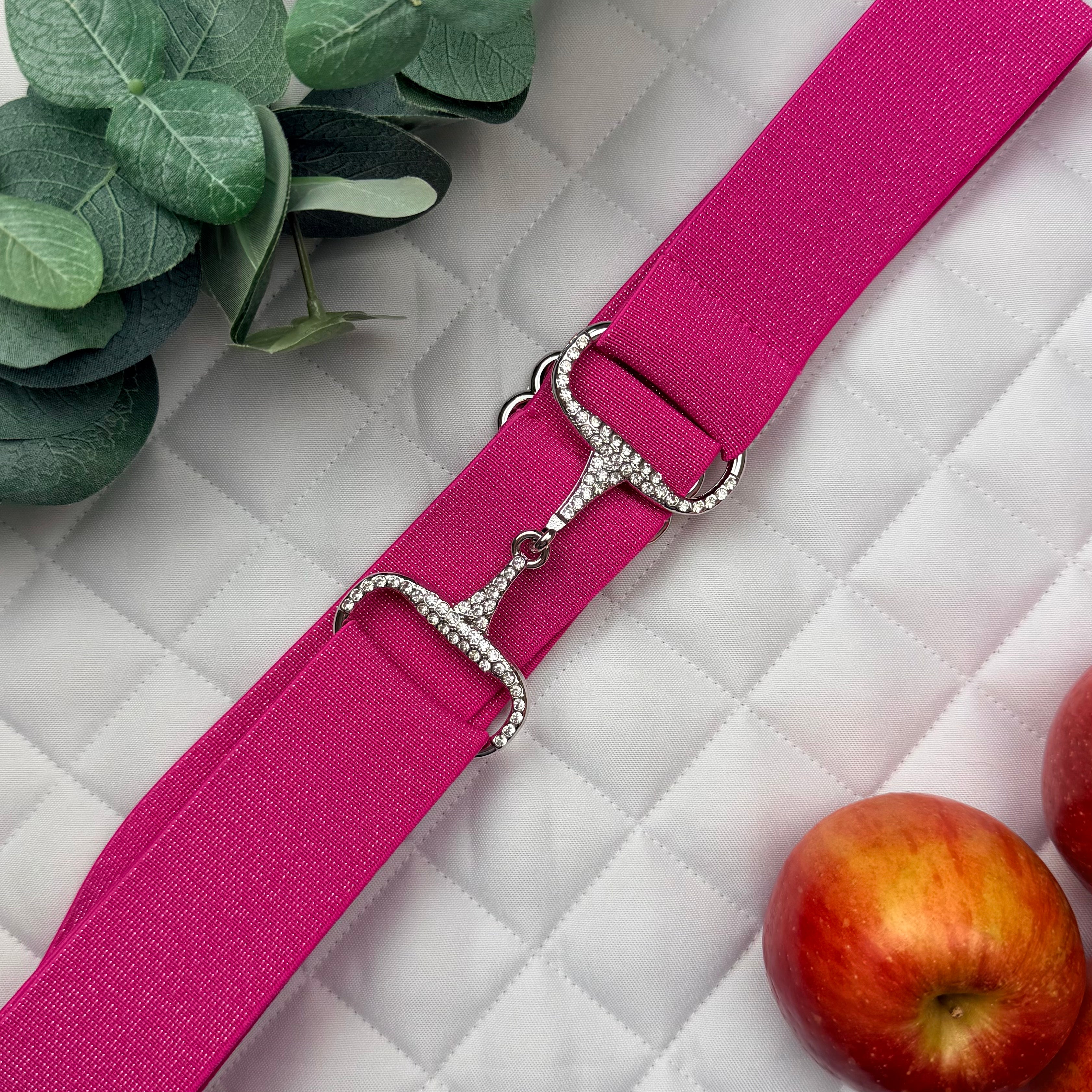 Pink equestrian belt with silver rhinestone buckle on a saddle pad with apples and leaves.